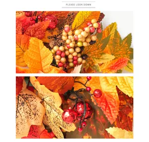 Autumn artificial wreath detail close-up showing vibrant maple leaves and glossy berries.