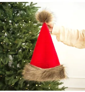 Close up view of festive red Christmas hat featuring soft brown faux fur brim and pom pom.
