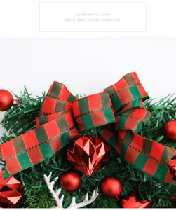 Christmas wreath detail view featuring red green plaid bow and shiny baubles festive decor