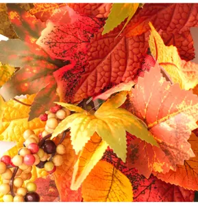 Detailed view of artificial autumn maple leaves and berries wreath for home decor and holiday.