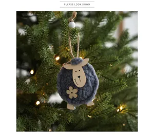 Dettaglio decorazione natalizia a pecora in feltro con viso in legno sull'albero.