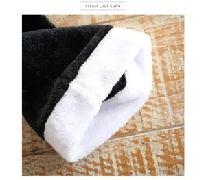 Black plush Christmas hat with thick white cuff, festive party costume accessory detail view.