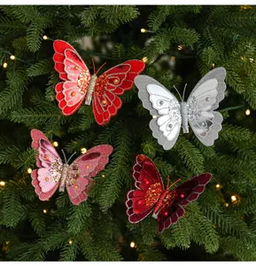 Détail de pinces papillon pailletées montrant des ailes scintillantes sur le sapin.