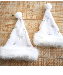 Detalle de gorros de Navidad de felpa blanca con copos de nieve de lentejuelas.