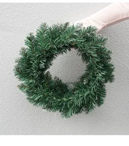 Detailed view of artificial Christmas wreath with frosted green pine tips for holiday decor.