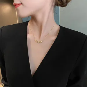 Vue de detail d'un collier creatif en perles dorees en acier titane, chaine chic et mate.
