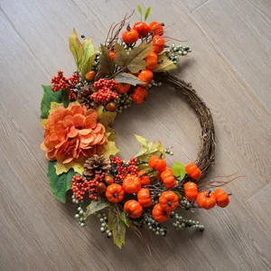 Herfst decoratieve krans met kunstmatige pompoenen, esdoornbladeren en bessen voor thuis.