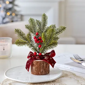 Mini Christmas tree table decoration with log base, artificial pine branches and red berries.