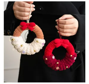 Gros plan de pendentifs mignons de couronne de Noël en peluche avec nœuds et cloches.