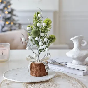 Mini Christmas tree tabletop decoration with log base, pine branches and white berries.