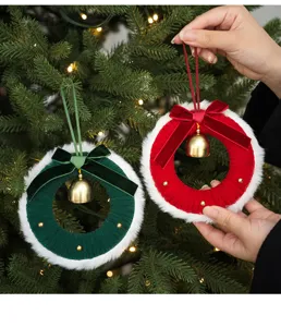 Détail d'ornement de couronne en peluche de Noël suspendue avec cloches rouges et vertes.