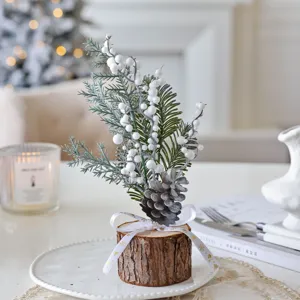 Mini Christmas tree table centerpiece with log base, white berries and pinecone decor.