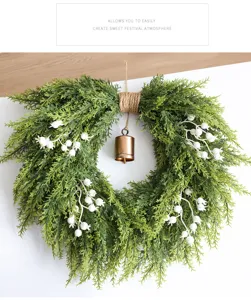 Kerst cederkrans met witte bessen en hangende bel voor voordeur vakantie huisdecoratie.