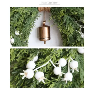 Kerst cederkrans detailshot met stijlvolle retro bronzen bel en witte bessen decoratie.