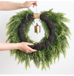 Gedetailleerd overzicht van kerstcederkrans met hangende bel en realistische dennentakken.