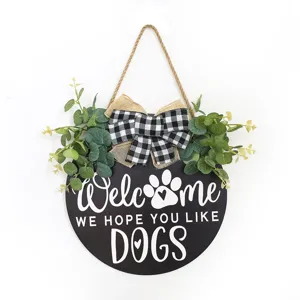 Détail de letrero de madera para puerta, placa redonda de bienvenida con lazo y eucalipto.