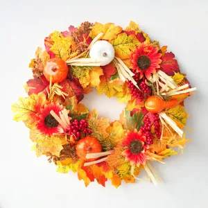 Autumn harvest wreath with artificial pumpkins, maple leaves, and berries for front door decoration