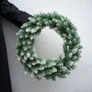 Flocked artificial Christmas wreath with white snow tips for front door holiday home decor.