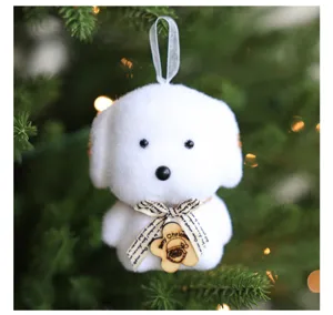 Close-up detail of white plush puppy dog Christmas tree hanging ornament with cute ribbon tag.