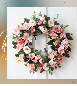 Gros plan détaillé d'une couronne de fleurs artificielles de roses et pivoines sur porte.