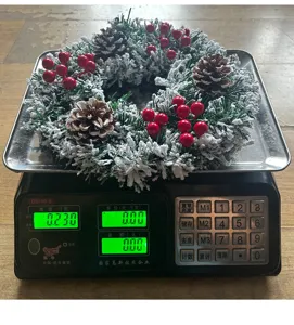 Weihnachtskranz Detailaufnahme mit Zapfen und Beeren, auf einer Waage gewogen.