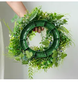 Artificial green foliage wreath detail showing plastic base and lush leaf design.