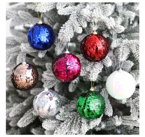 Primer plano de bolas de Navidad coloridas con lentejuelas colgadas en ramas nevadas