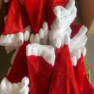 Vista detallada de gorro de Navidad de felpa, suave tela de terciopelo rojo con borde blanco.