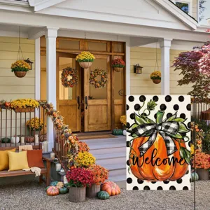 Autumn garden flag hanging on porch decorated with pumpkins and flowers for outdoor decor