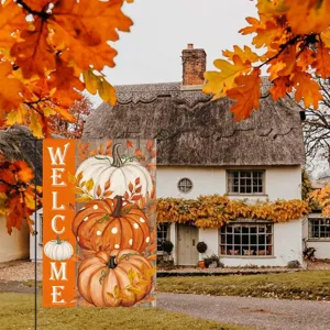 Autumn garden flag detail showcasing vibrant pumpkin print and welcome text in outdoor scene.
