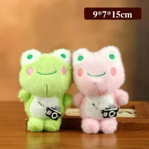 Primer plano detallado de lindos juguetes de peluche de rana con colgante de mini cámara suave.