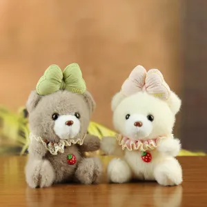 Plush bear pendant with bow and strawberry charm, cute stuffed animal detail display.