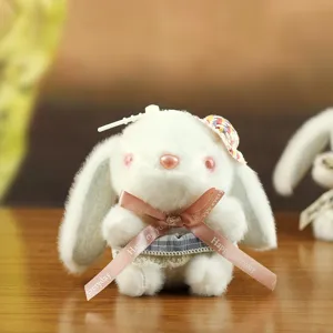 Cute plush rabbit doll pendant with pink ribbon bow and plaid skirt, perfect bag charm.
