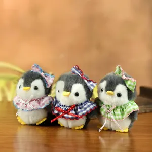Primo piano dettagliato di tre bellissimi pinguini di peluche con fiocchi a quadretti.