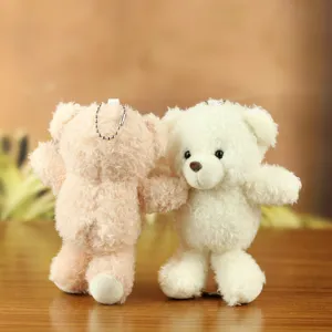Close-up detail shot of cute paired fluffy teddy bear plush pendants with metal ball chains.