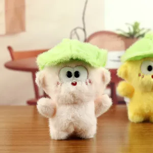 Gros plan détaillé du pendentif singe en peluche mignon avec chapeau de feuille verte, jouet poupée.