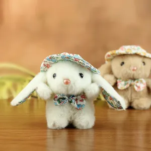 Dettaglio di peluche coniglio con cappellino floreale, tessuto morbido e grazioso fiocco.