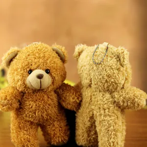 Detailed view of cute plush teddy bear keychain, soft fluffy toy pendant for bags and keys.