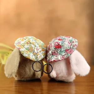 Dettaglio portachiavi coniglio di peluche, cappello floreale, giocattolo soffice, anello.