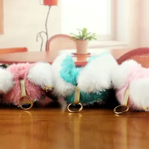 Detailansicht niedlicher, flauschiger Plüsch-Puppen-Schlüsselanhänger mit goldenen Ringen.