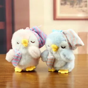Grazioso ciondolo pinguino di peluche con cuffia da notte, vista dettagliata del peluche.