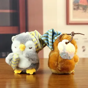 Simpatici peluche di pinguino e uccello con cappelli a righe, vista ravvicinata.