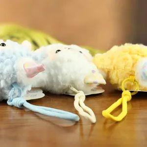 Primo piano dettagliato di portachiavi in peluche di pecorella carini con cordini colorati morbidi.