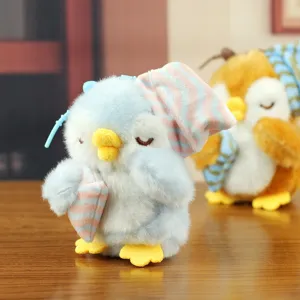 Primo piano dettagliato del simpatico peluche pinguino blu con cuscino e berretto.