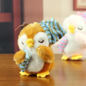 Dettaglio pendente pinguino di peluche morbido con tessuto soffice e cappello a righe blu.