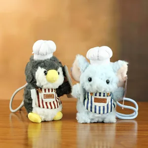 Nahaufnahme von süßen Koch Pinguin und Elefant Plüschtieren mit gestreiften Schürzen.