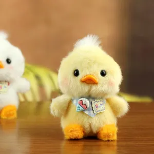 Süßes Plüsch gelbes Enten Spielzeug Anhänger mit Lätzchen, Detailansicht weicher Textur.