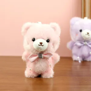 Primer plano detallado del colgante de bolso de oso de peluche rosa con lazo.