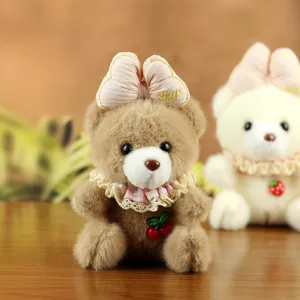 Detailed view of cute plush bear pendant with pink bow, lace collar and sweet cherry charm.
