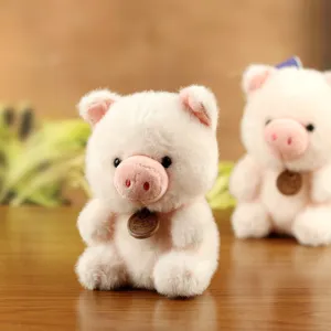 Close-up detail of a cute pink plush pig doll with a small wooden tag, soft and lovely charm.